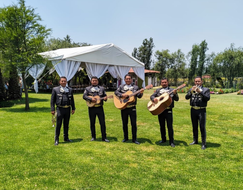 Mariachis tocando en evento especial sobre trajinera en Xochimilco